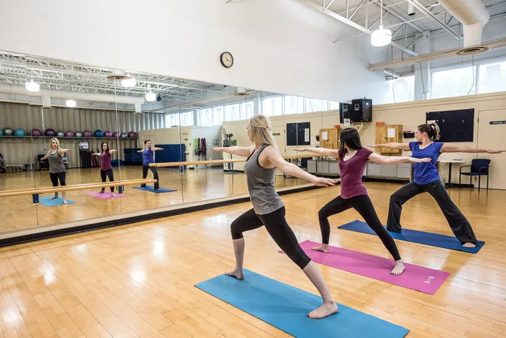 three women practice yoga in sackville sports stadium